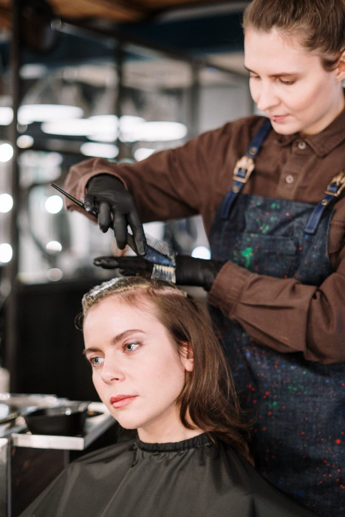 A stylist colours a client's hair in a salon