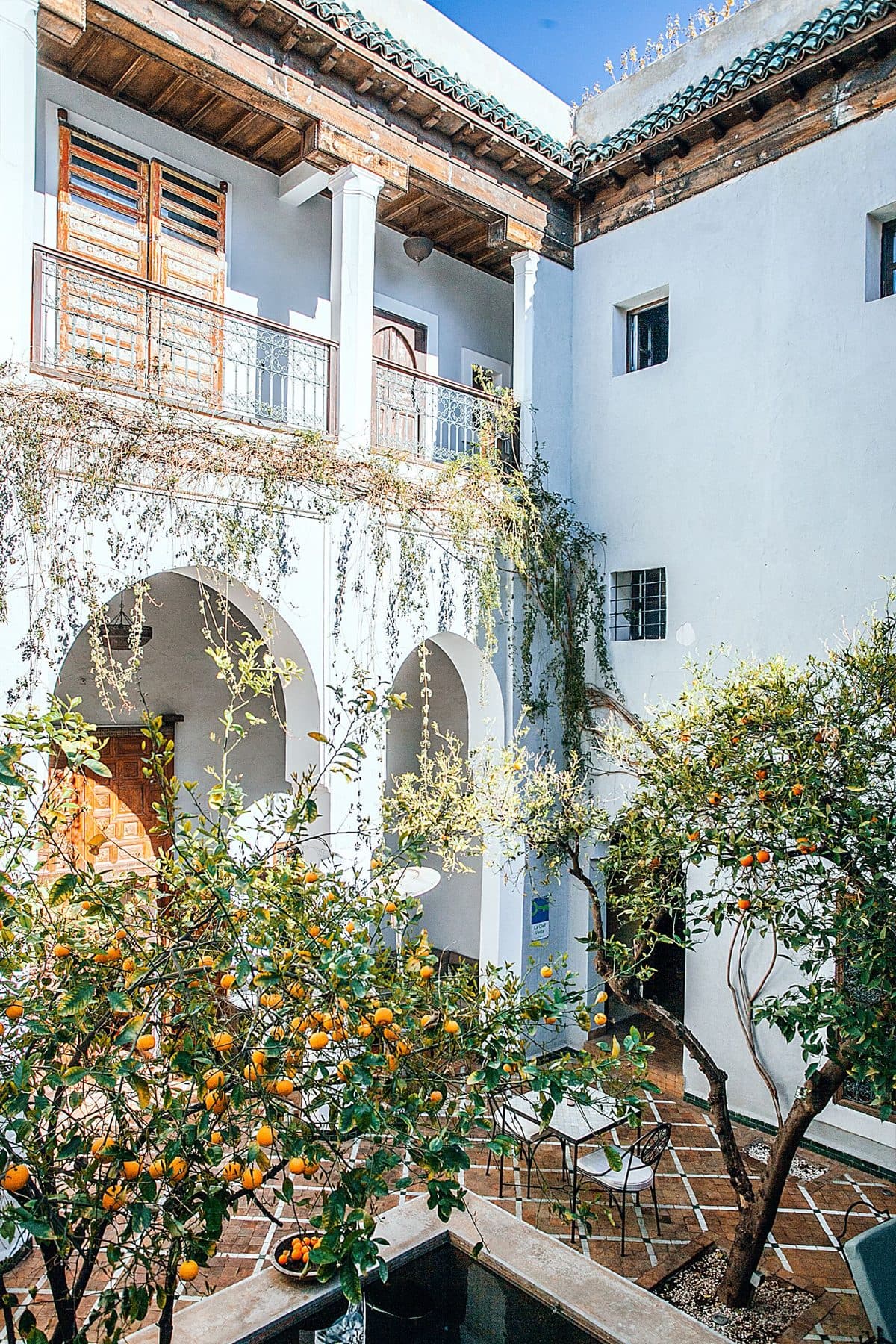 A Mediterranean hotel courtyard with arches and citrus trees