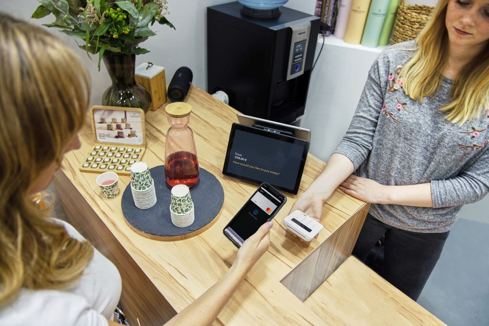 A café owner serves customers at the counter