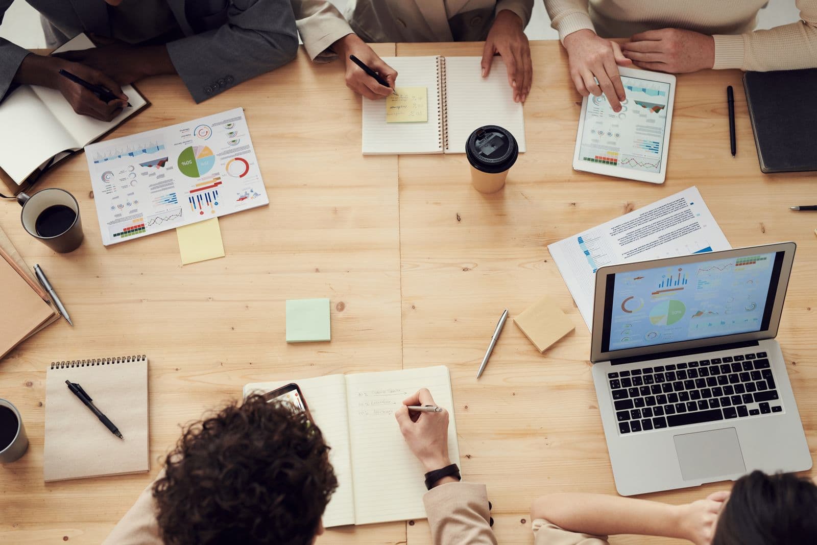 A marketing team's desk with charts, notebooks and a laptop